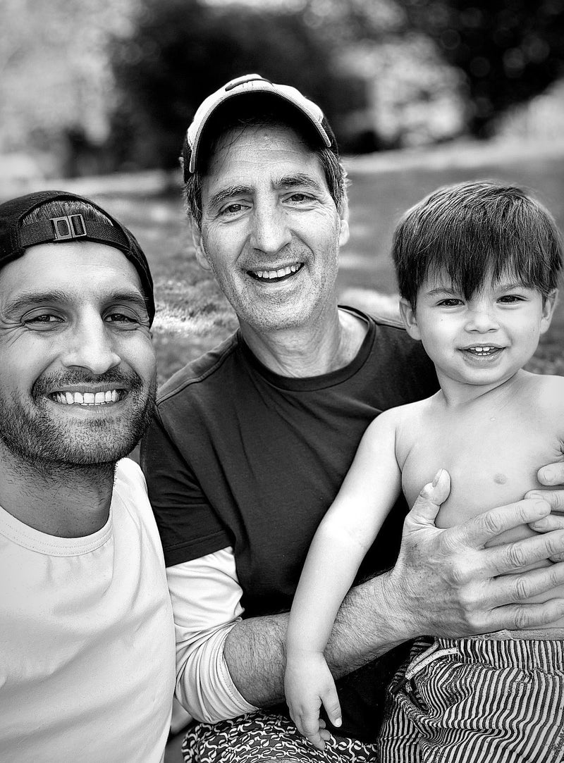 Two men, including Wild Roman founder Sahil Bloom, and a child posing for a photo outdoors
