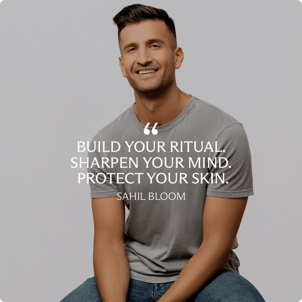 A smiling Sahil Bloom in a gray crew-neck t-shirt and blue jeans sits against a light gray background, with white text overlaid reading: 'BUILD YOUR RITUAL. SHARPEN YOUR MIND. PROTECT YOUR SKIN."