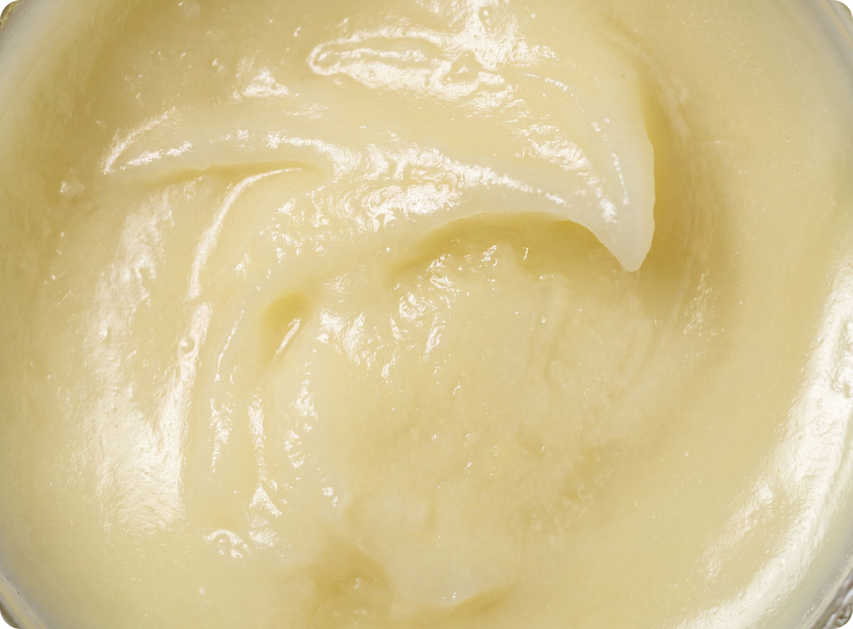 Macro close-up of rich, creamy pale yellow Wild Roman moisturizer texture