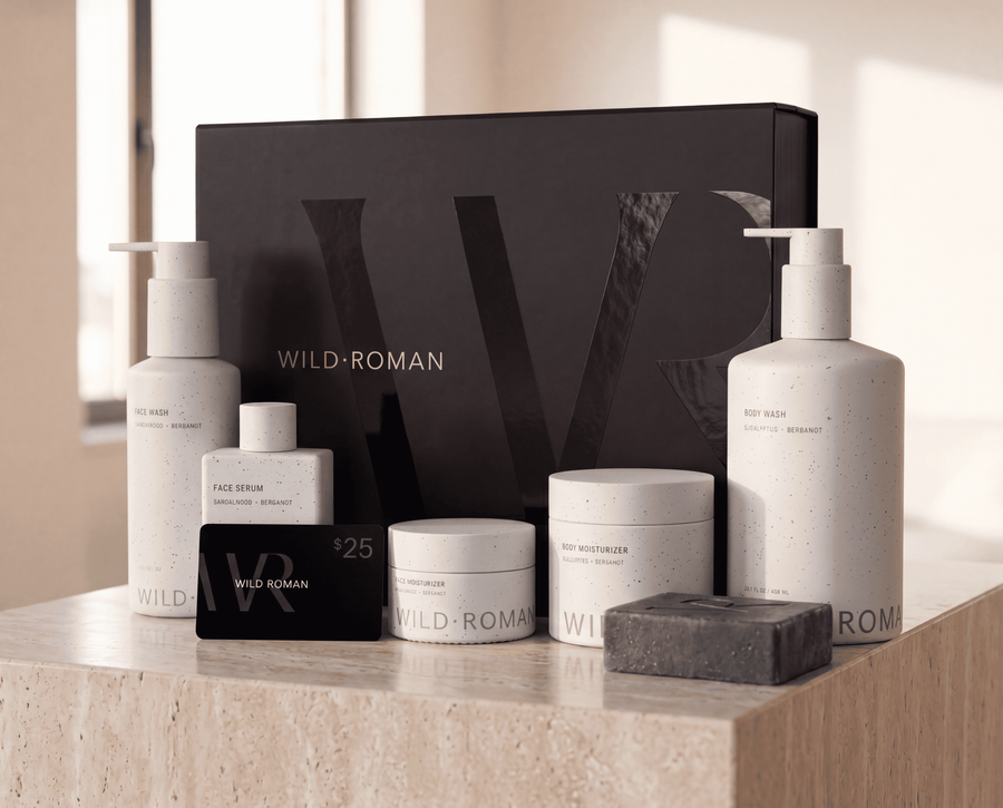 Collection of Wild Roman men's natural skincare products on a marble surface with a blurred background
