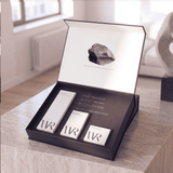 Set of skincare products in a black box on a wooden surface